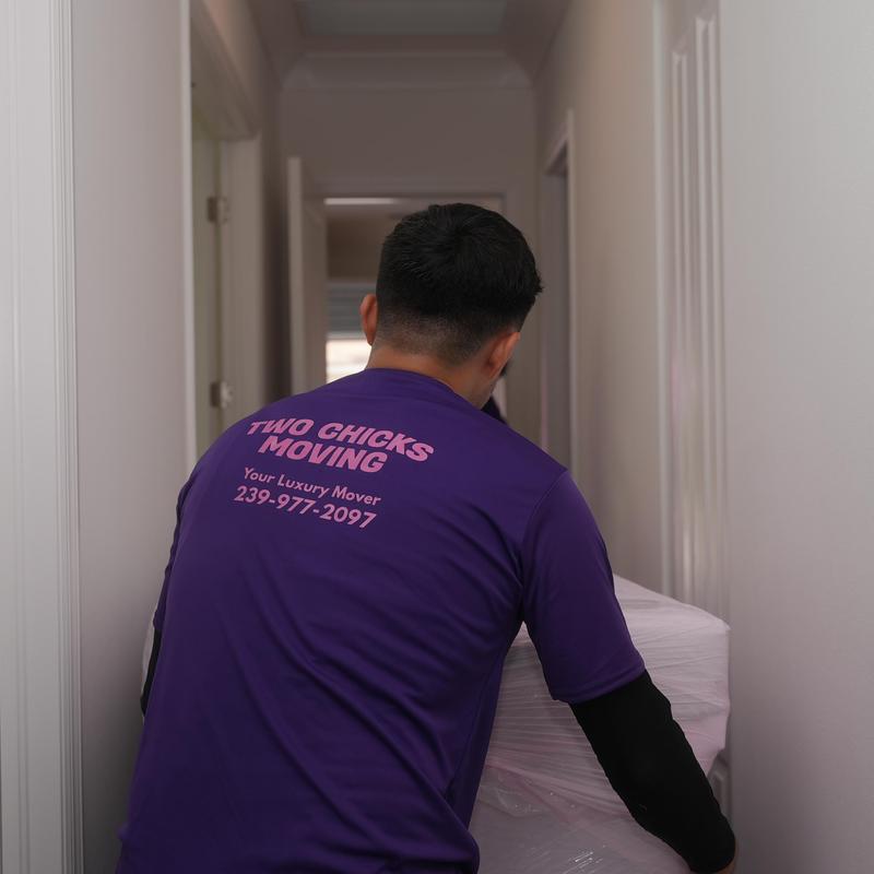Wrapped furniture moving through hallway by Two Chicks Moving