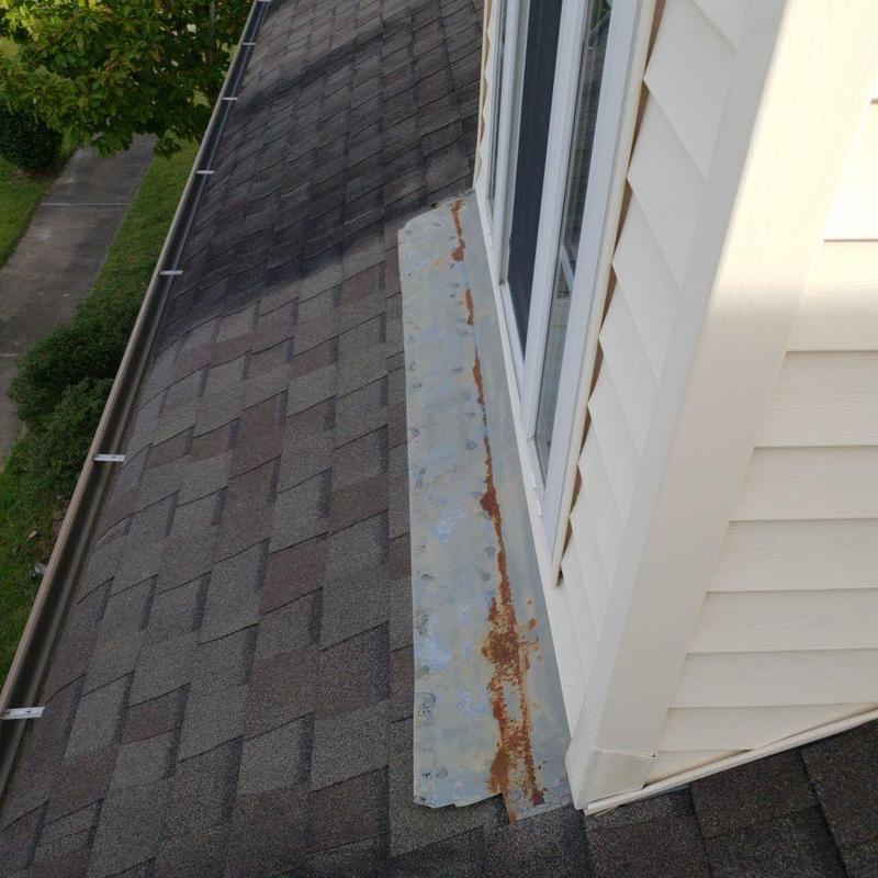 Metal flashing on asphalt shingle roof near window