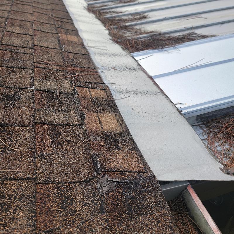 Asphalt shingle roof edge with metal flashing and debris Asphalt shingle roof edge with metal flashing and debris
