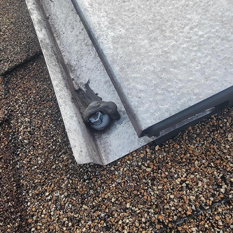 Metal drip edge with loose roofing nail on asphalt shingles Metal drip edge with loose roofing nail on asphalt shingles