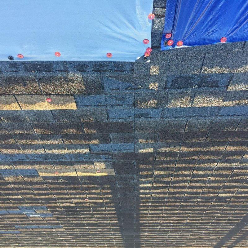 Asphalt shingles with hail damage markers on roof