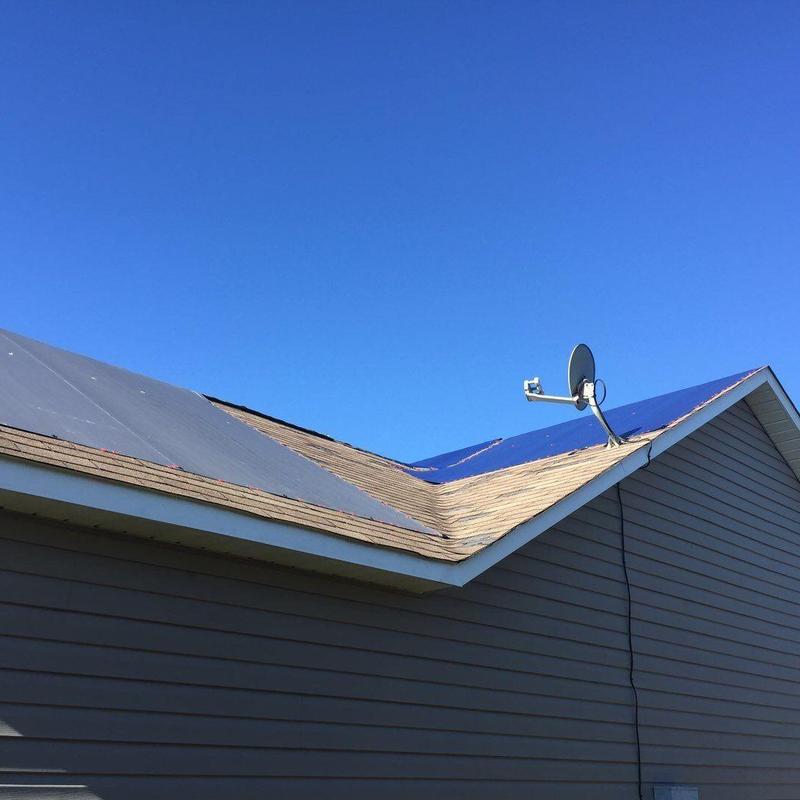 Roof shingles inspection after hail damage with satellite dish