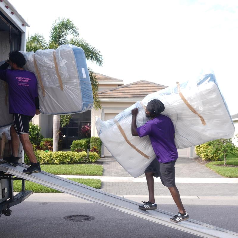 Mattresses wrapped in plastic being loaded onto truck