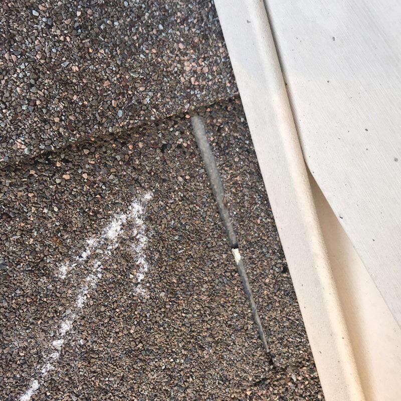 Asphalt shingle roof with crack near flashing edge