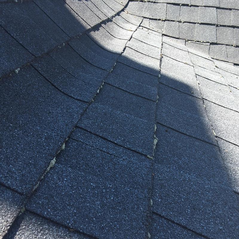 Asphalt shingle roof transition with damage and wear Asphalt shingle roof transition with damage and wear
