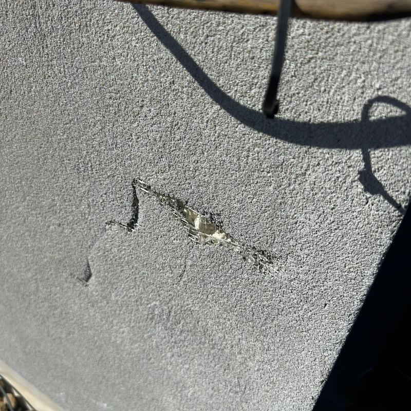 Roofing membrane puncture with exposed layers and wire mesh Roofing membrane puncture with exposed layers and wire mesh
