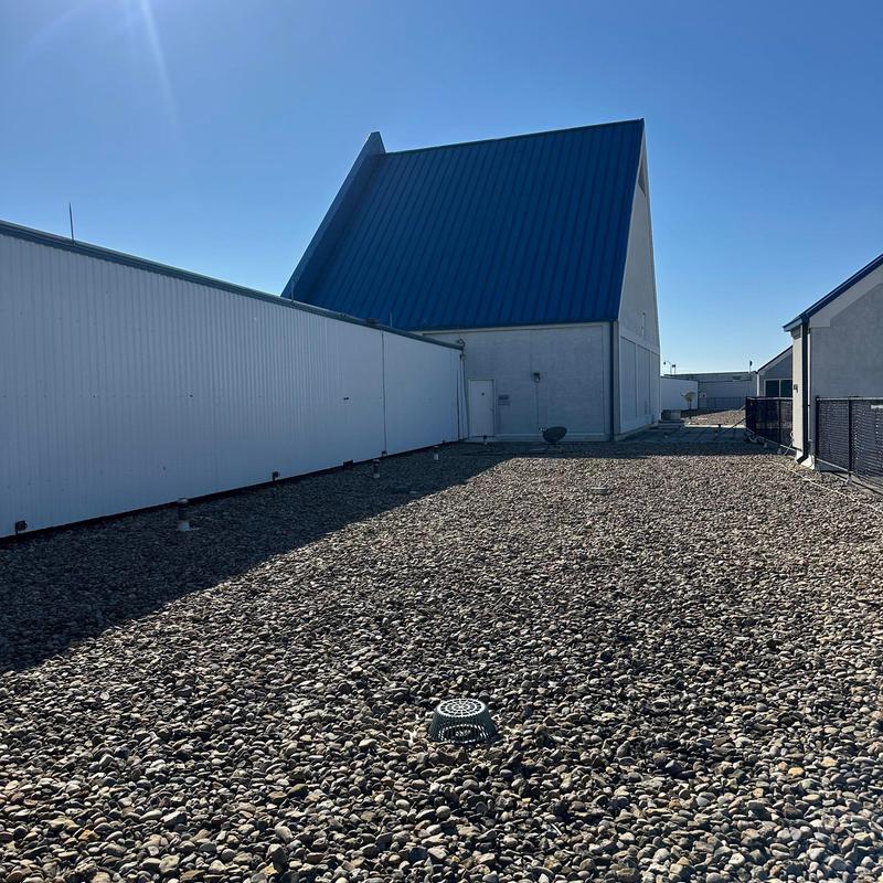 Gravel-covered commercial roof with drainage vent Gravel-covered commercial roof with drainage vent