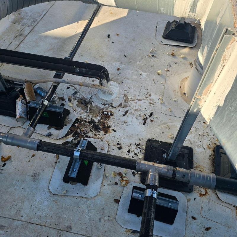 Rooftop pipe system with rust and debris on membrane Rooftop pipe system with rust and debris on membrane