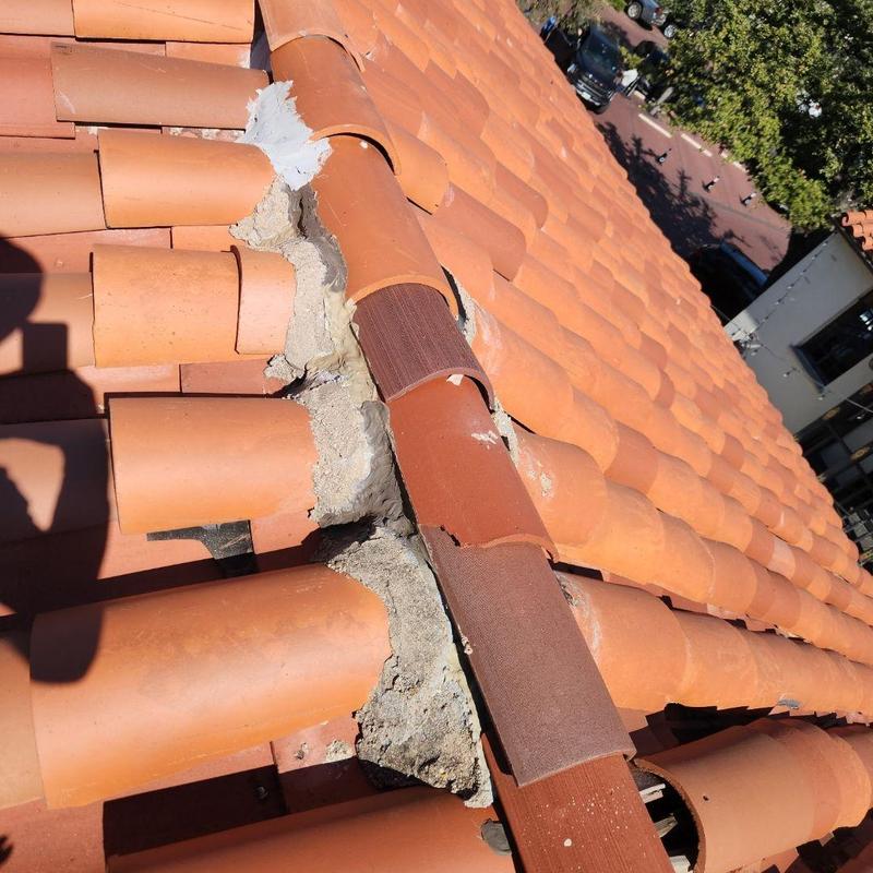 Clay tile ridge with broken and cracked tiles on roof Clay tile ridge with broken and cracked tiles on roof