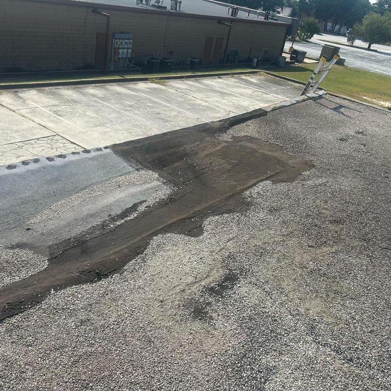 Low-slope roof repair patched on gravel surface Low-slope roof repair patched on gravel surface
