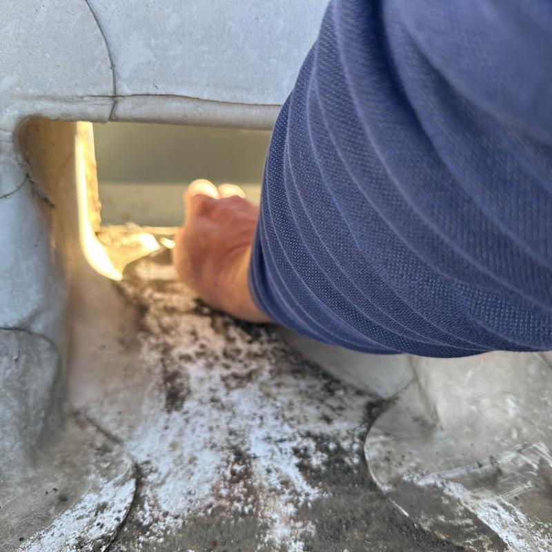 Roof drain inspection showing debris buildup and hand access Roof drain inspection showing debris buildup and hand access