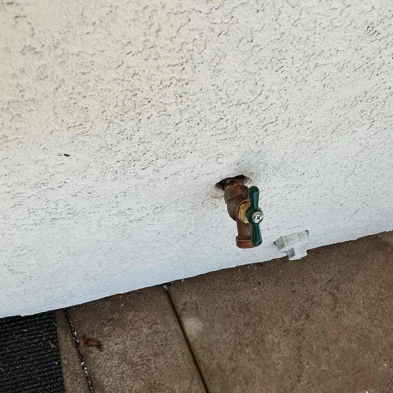 Brass hose bib installed on exterior stucco wall