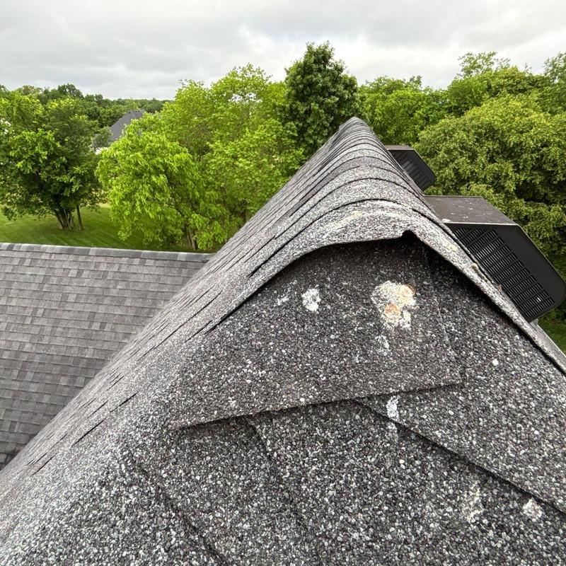Asphalt roofing shingles curling and storm damage close-up