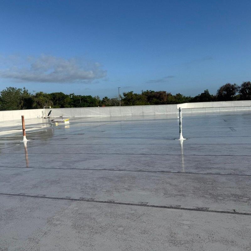 Low-slope membrane roof with sealed pipe penetrations Low-slope membrane roof with sealed pipe penetrations
