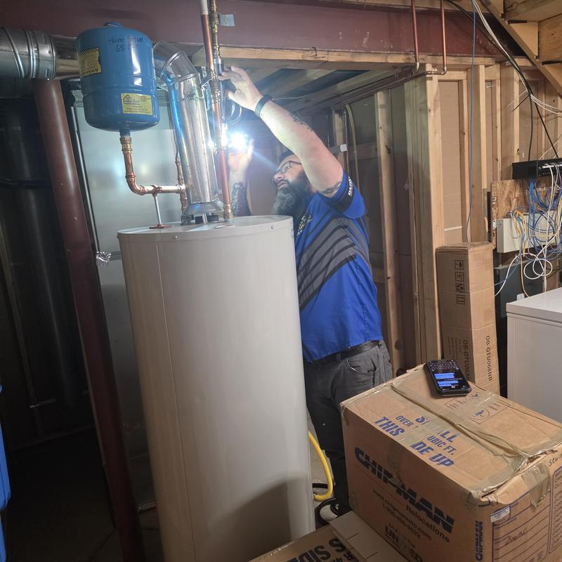 Water heater flush maintenance with technician using flashlight