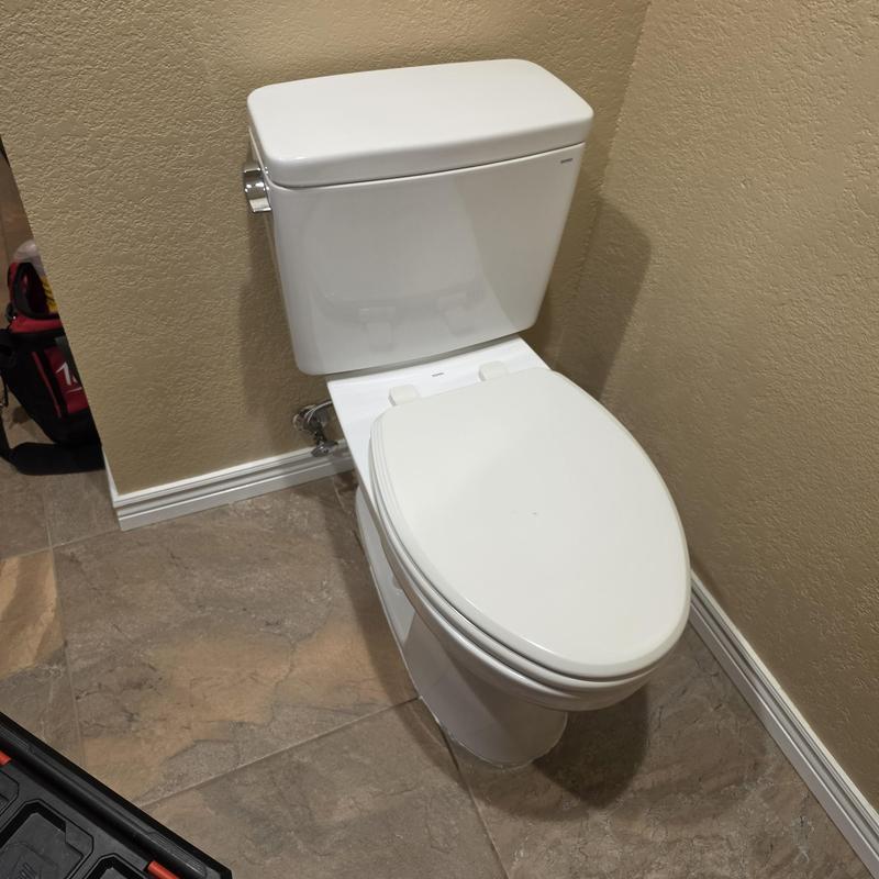 Two-piece toilet installation in bathroom corner