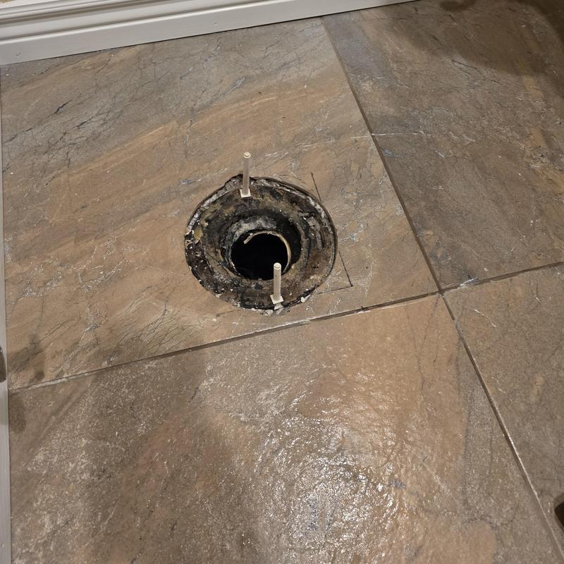 Toilet flange on tiled floor with mounting bolts