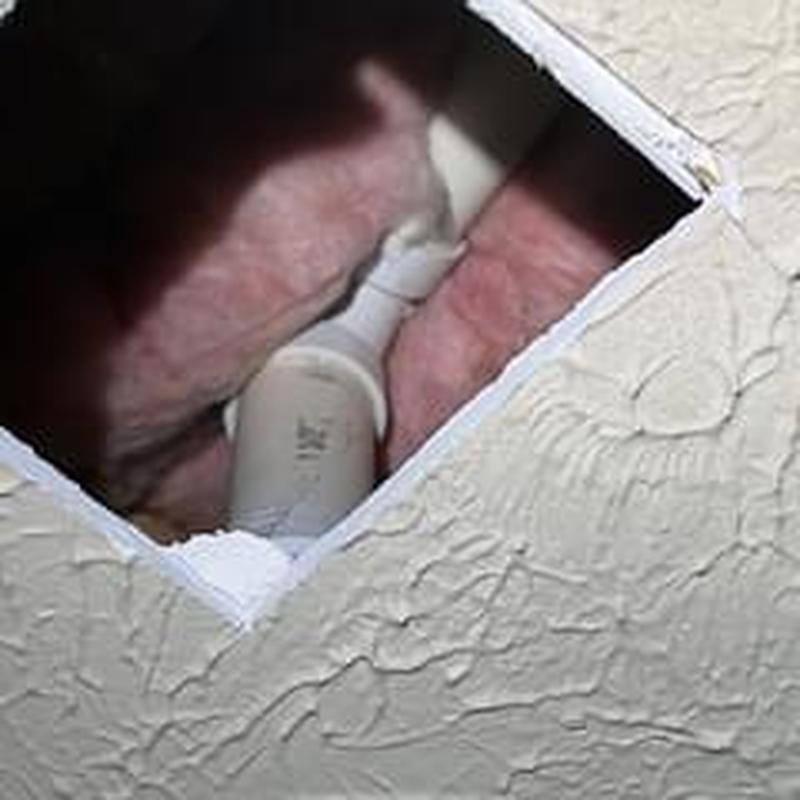 Shower drain pipe with temporary leak repair in ceiling