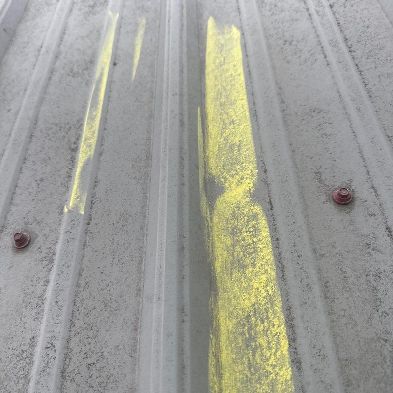 Metal roof panels with yellow chalk marks for inspection