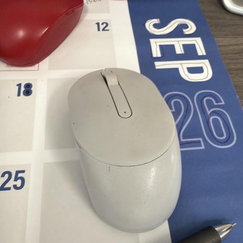 Computer mouse on a desk calendar with pen nearby Computer mouse on a desk calendar with pen nearby