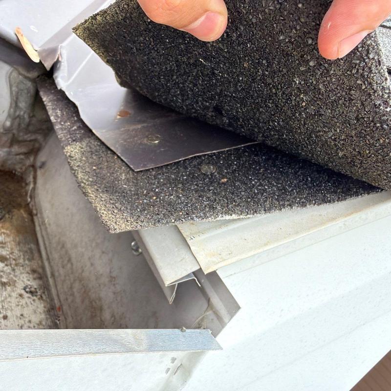 Roofing shingles lifted to inspect flashing condition