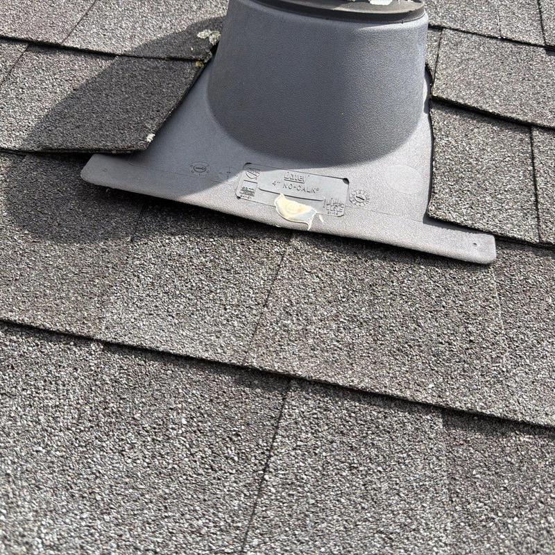 Roof vent flashing on asphalt shingle roof with hail damage