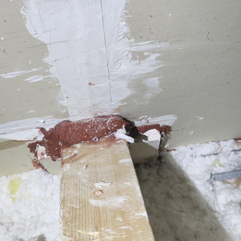 Attic beam sealed with brown fireproof caulk and insulation Attic beam sealed with brown fireproof caulk and insulation