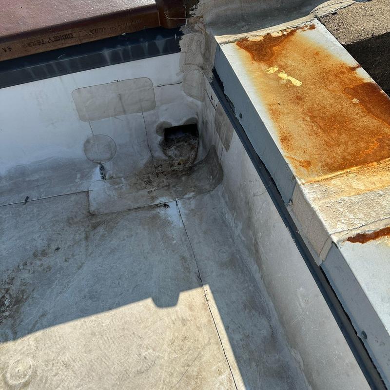 Concrete roof with patched drainage area and rusted metal edge Concrete roof with patched drainage area and rusted metal edge
