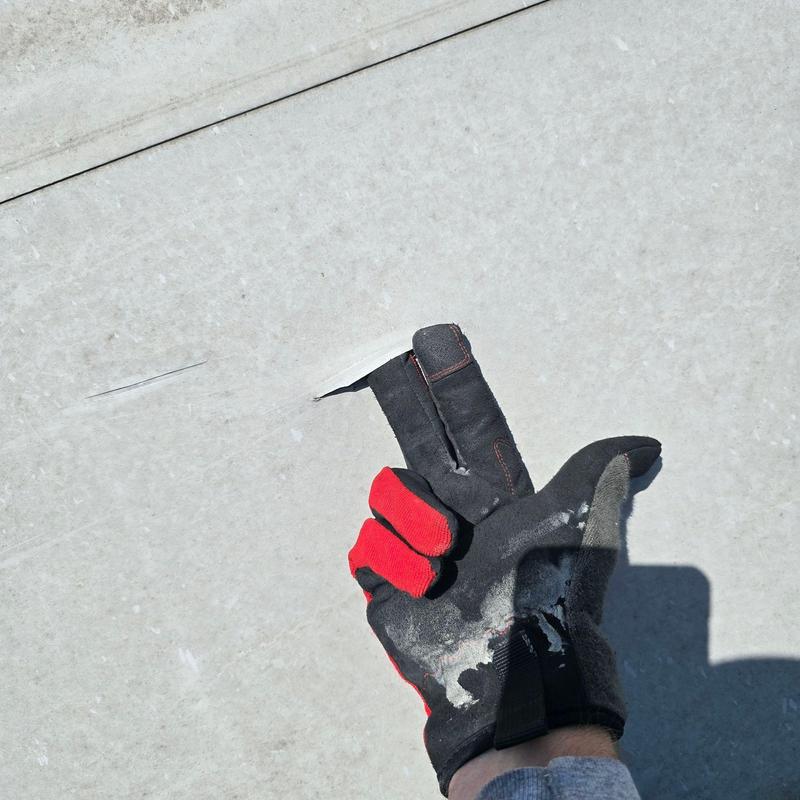 Concrete commercial roof with damage and worker glove Concrete commercial roof with damage and worker glove