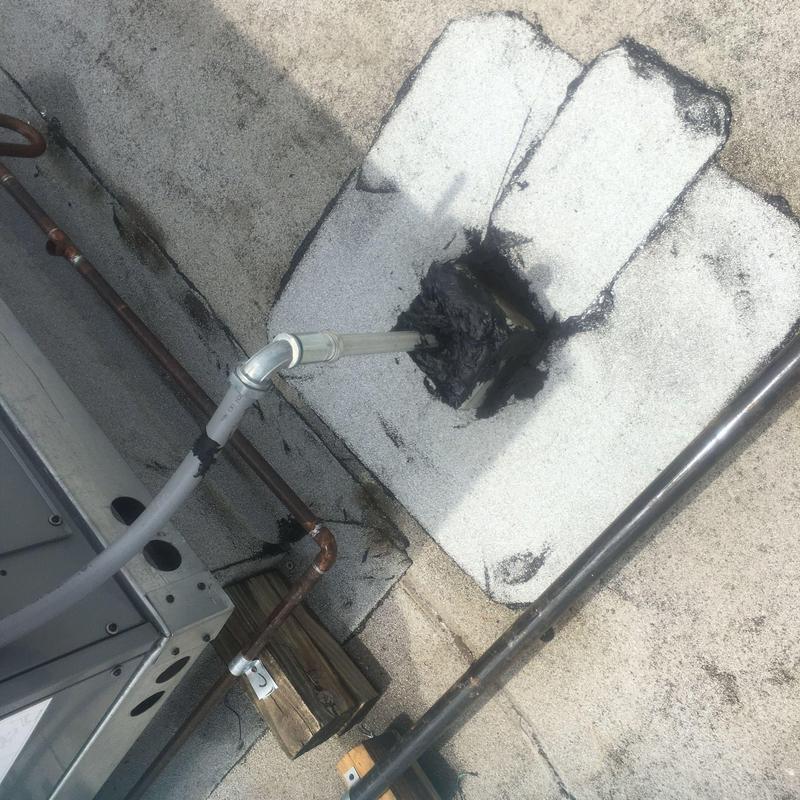 Concrete roof pipe penetration sealed with roofing tar Concrete roof pipe penetration sealed with roofing tar