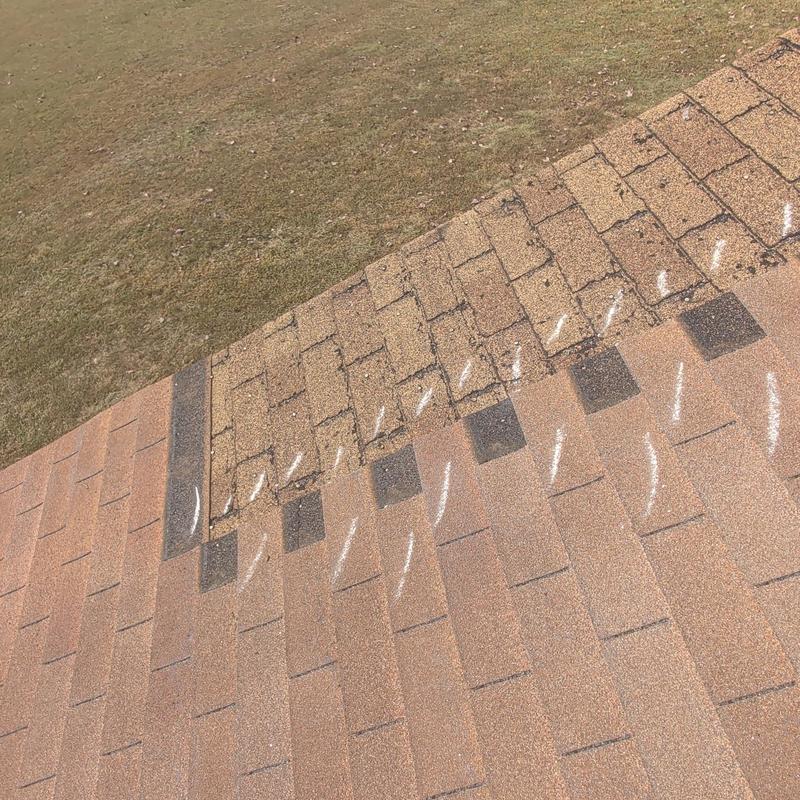 Hail-damaged roof shingles with white markings