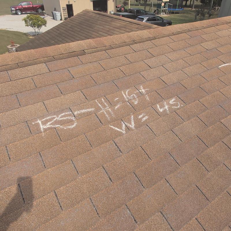 Asphalt shingle roof with chalk markings and damage notes