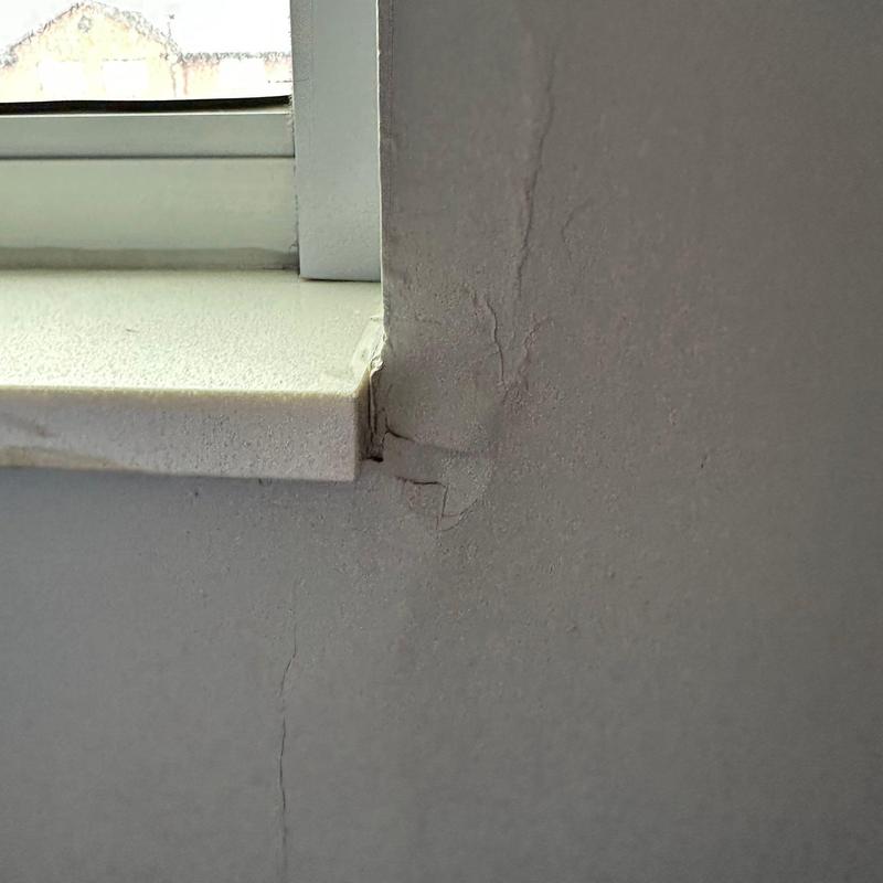 Stucco wall cracks near window frame corner Stucco wall cracks near window frame corner