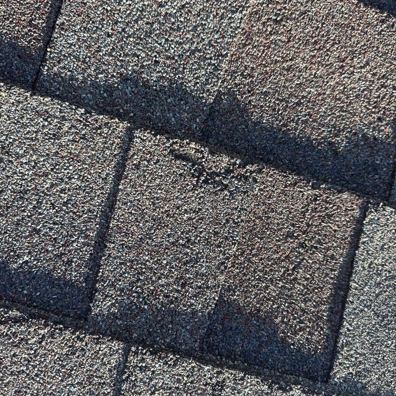 Shingle roof showing storm damage and repairs Shingle roof showing storm damage and repairs