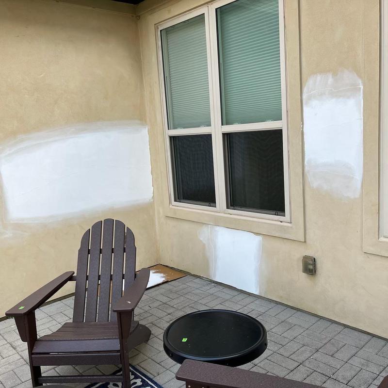 Stucco wall patches with fresh paint near patio Stucco wall patches with fresh paint near patio