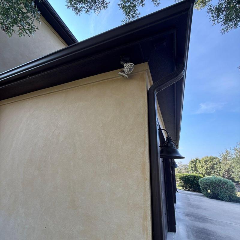 Stucco exterior wall with black gutter and light fixture Stucco exterior wall with black gutter and light fixture