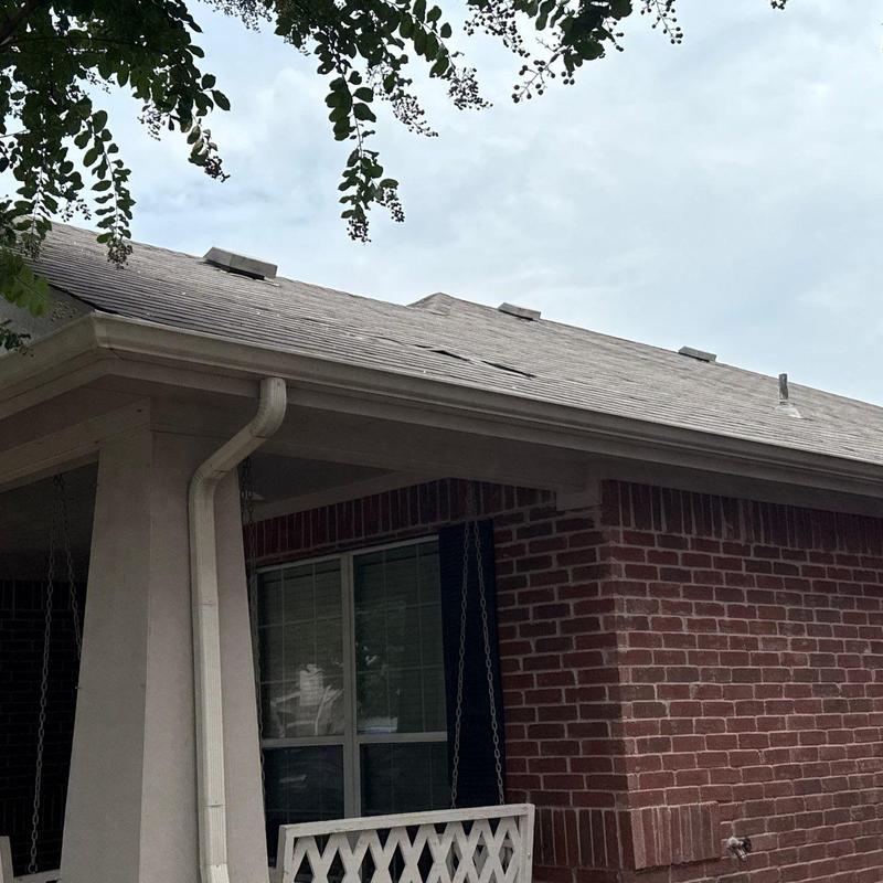 Shingle roof with storm damage on brick house Shingle roof with storm damage on brick house