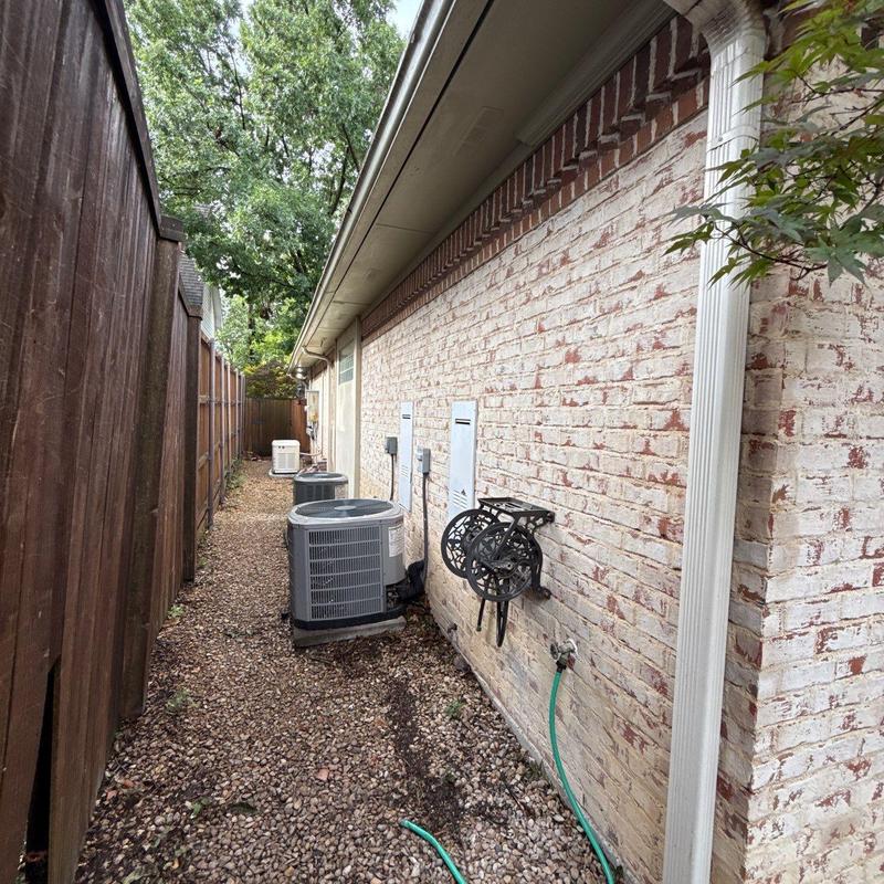 Outdoor air conditioning units along brick house exterior Outdoor air conditioning units along brick house exterior