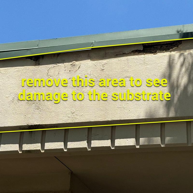 Stucco siding with visible surface damage near roofline Stucco siding with visible surface damage near roofline