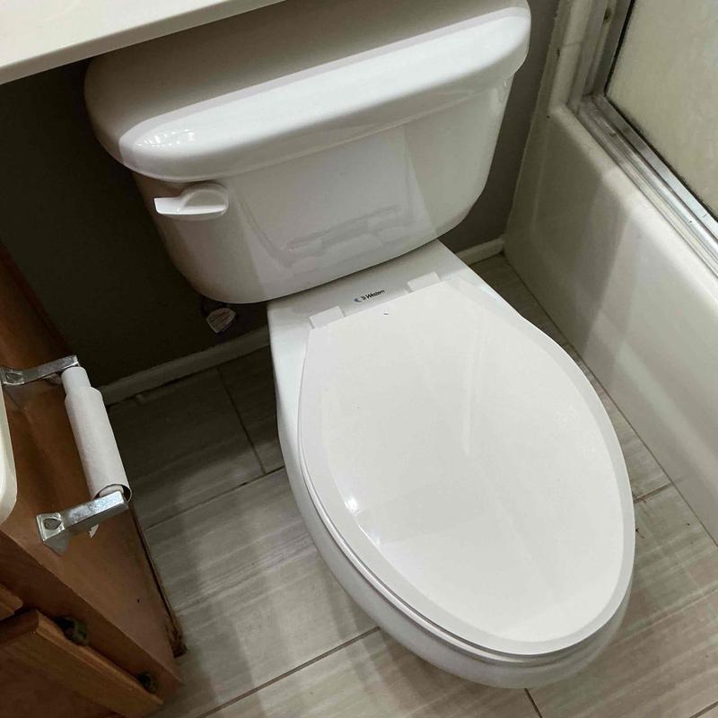 Low-profile toilet installation in bathroom corner