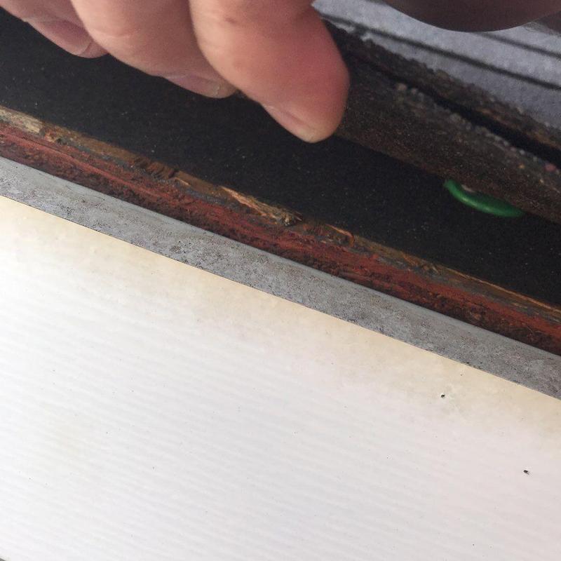 Roof flashing being inspected under roofing material
