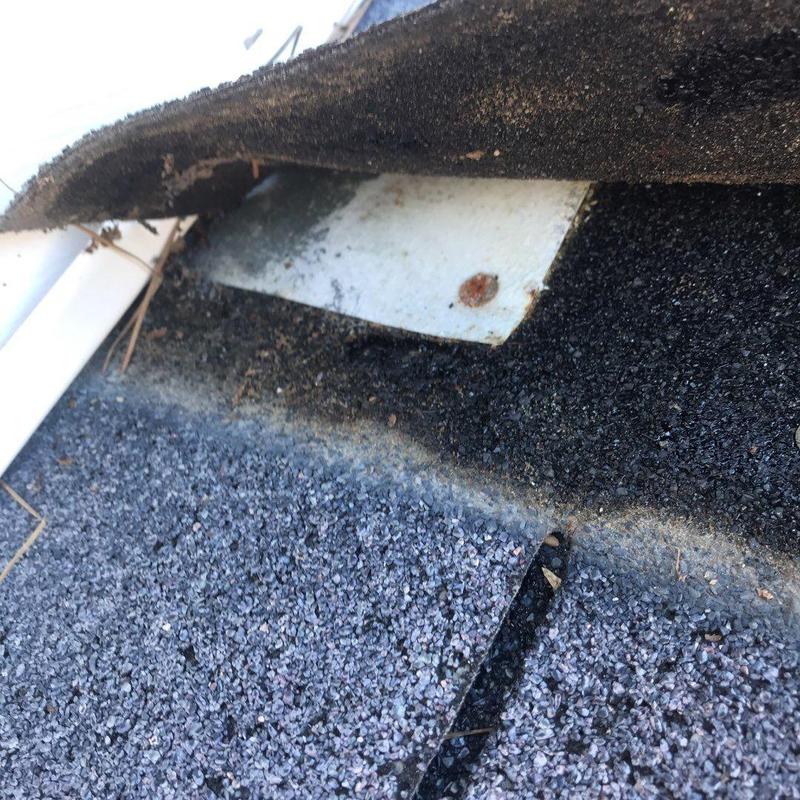 Asphalt shingle roof with exposed underlayment and flashing
