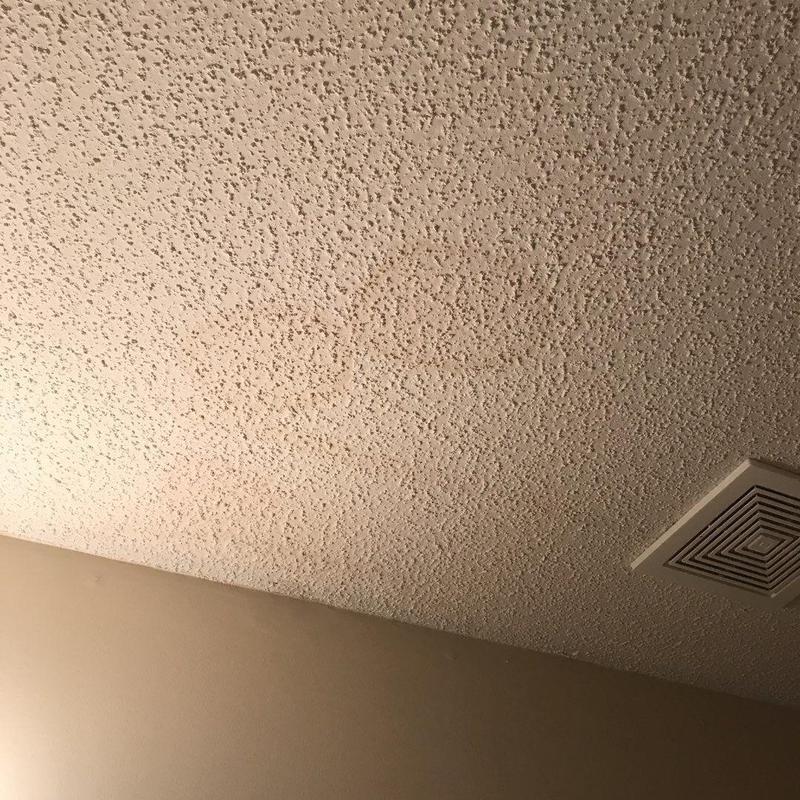 Popcorn ceiling with visible water stains near vent