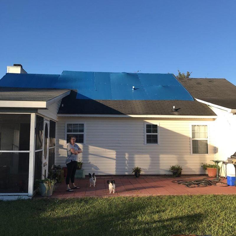 Shingle roof with temporary blue tarp cover