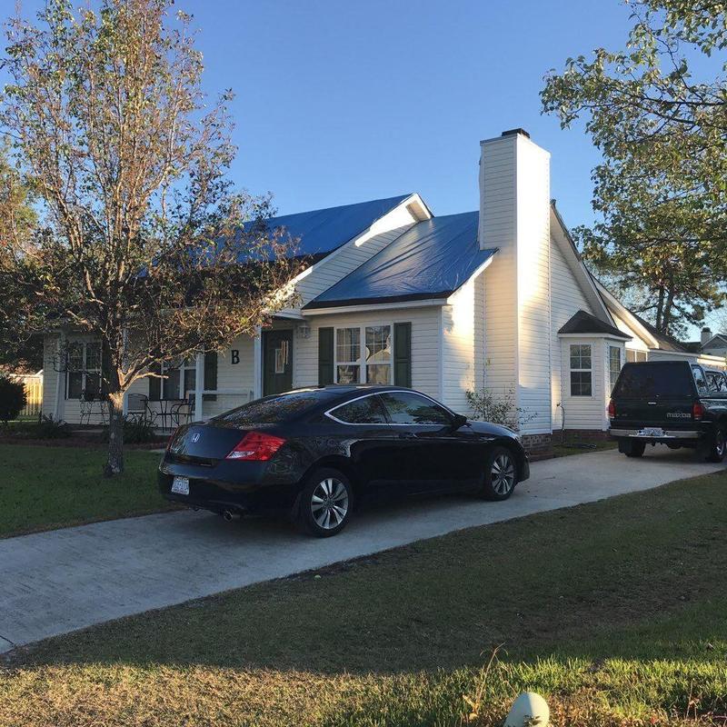 Shingle roof with protective tarp after damage