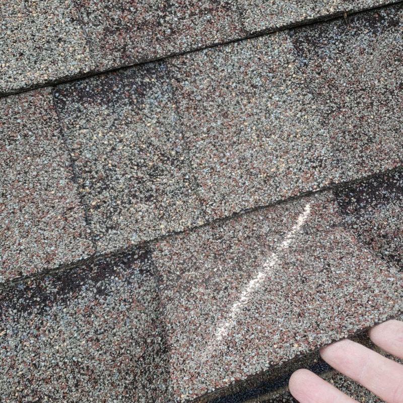 Asphalt shingle showing hail damage on roof surface