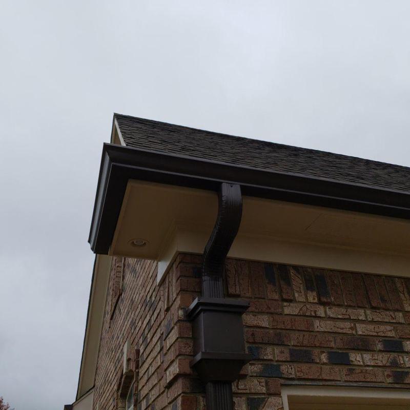 Shingle roof with gutter and downspout on brick house