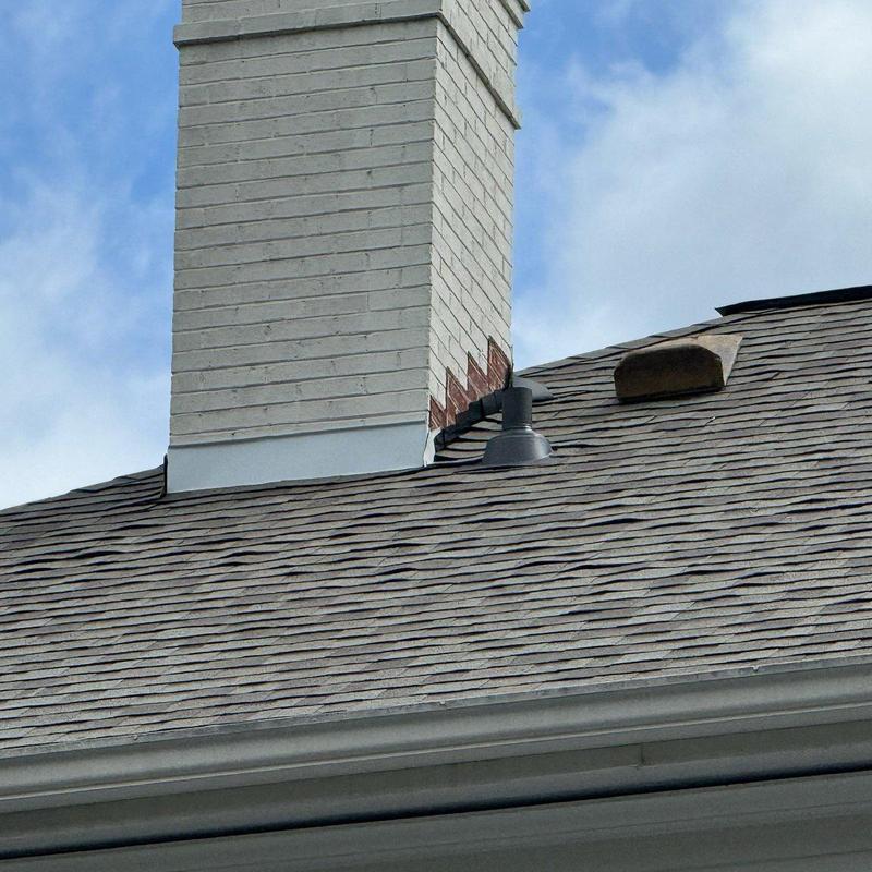 Asphalt shingle roof near brick chimney with vent Asphalt shingle roof near brick chimney with vent