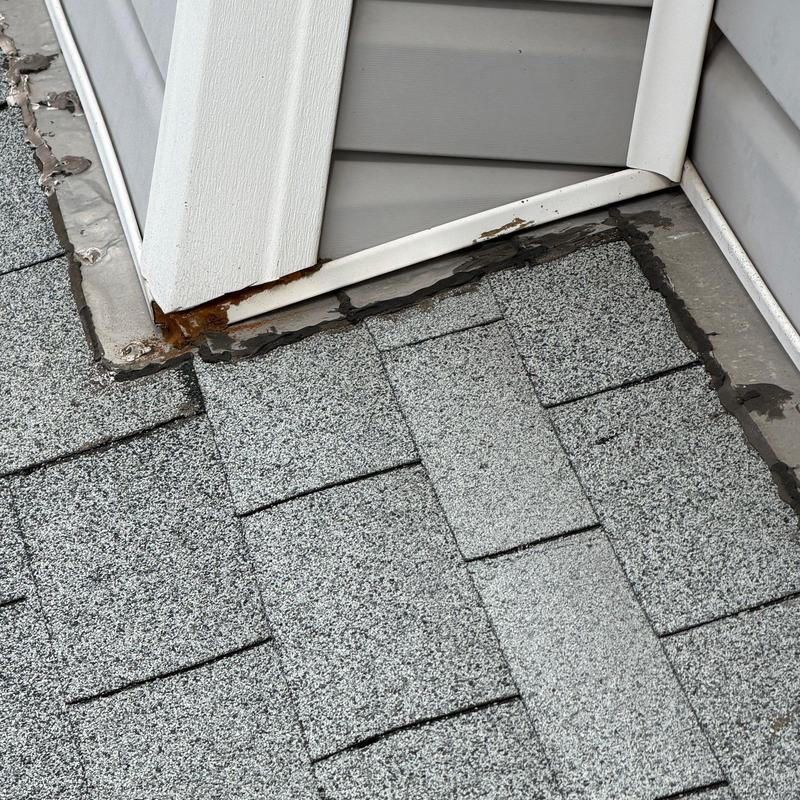 Roof-to-wall flashing with rust and cracked sealant Roof-to-wall flashing with rust and cracked sealant