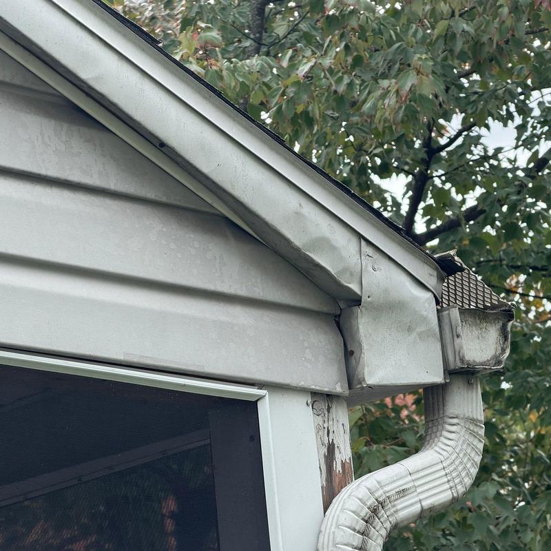 Gutter downspout with damaged and rusted edges Gutter downspout with damaged and rusted edges